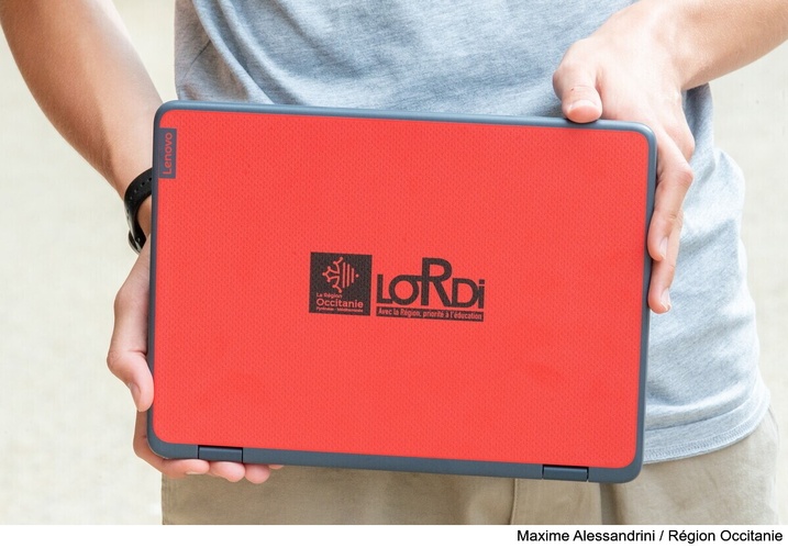 Un élève tient l’ordinateur portable « Lordi » devant lui.