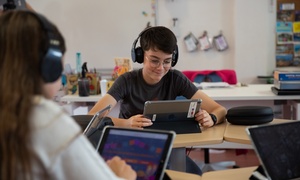 Deux élèves consultent une ressource sur tablette avec un casque audio